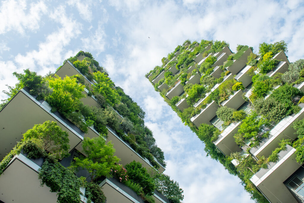 The image shows an example of green building: the Bosco Verticale (Vertical Forest) in Milan, designed by Boeri Studio, is so called because each tower houses trees between 3 and 6 metres. Their function? To help mitigate smog and produce oxygen.
